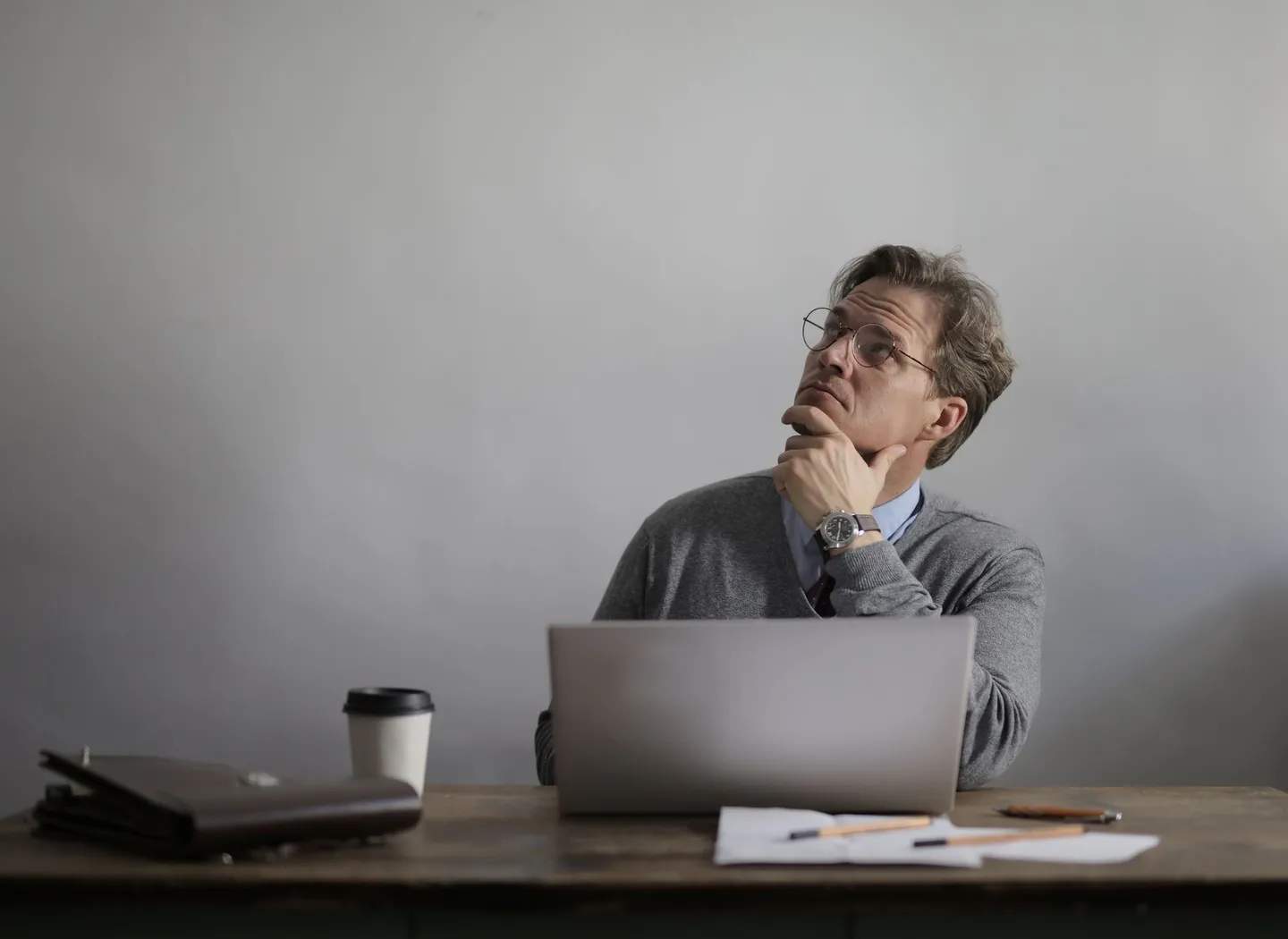 Person resting their chin on their hand while working at a laptop