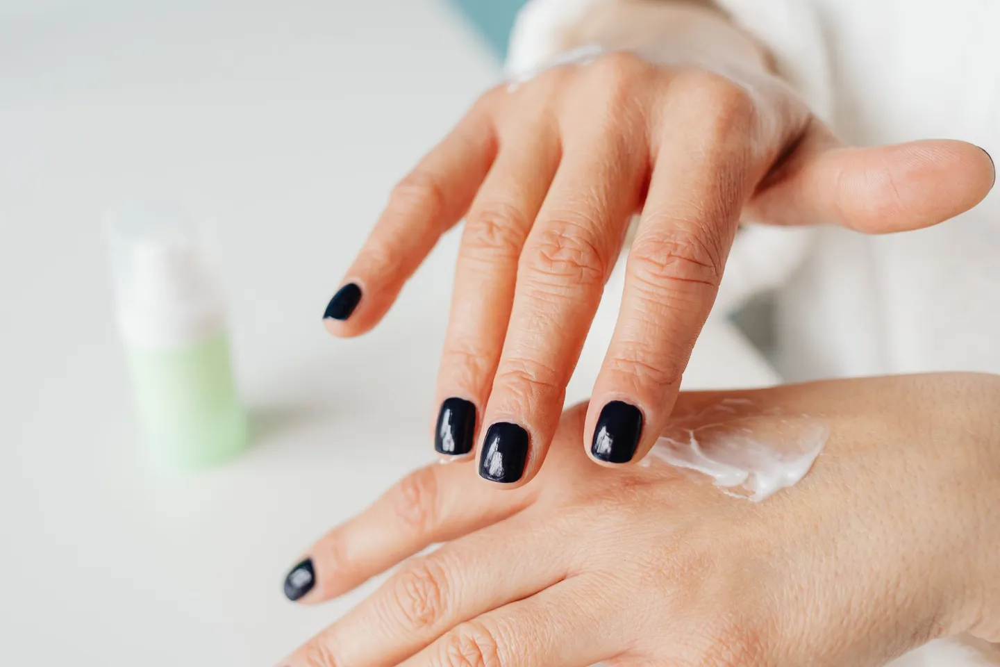 Close-up of hands gently applying cream to the skin