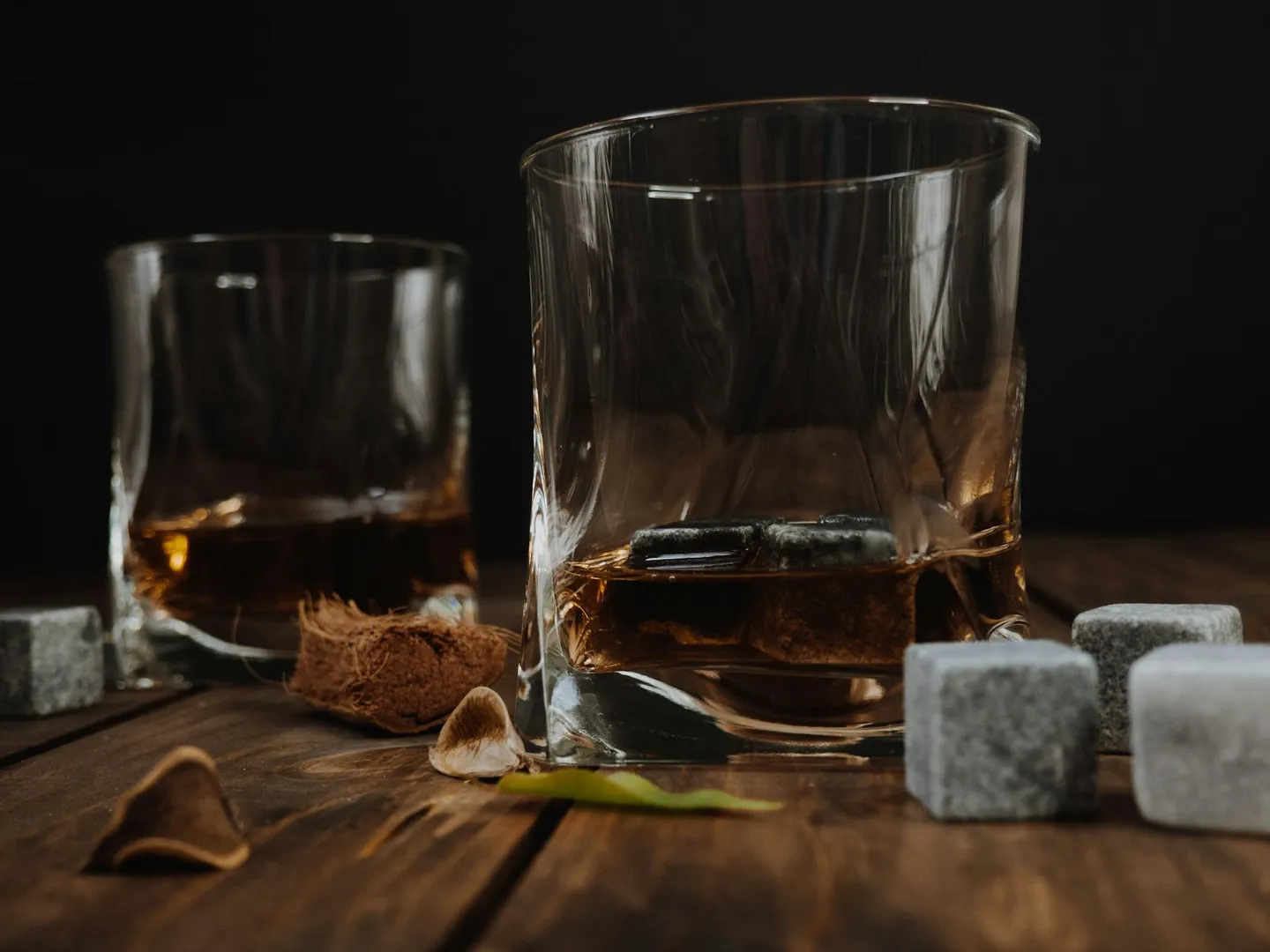 A clear glass of water resting on a dark wooden table