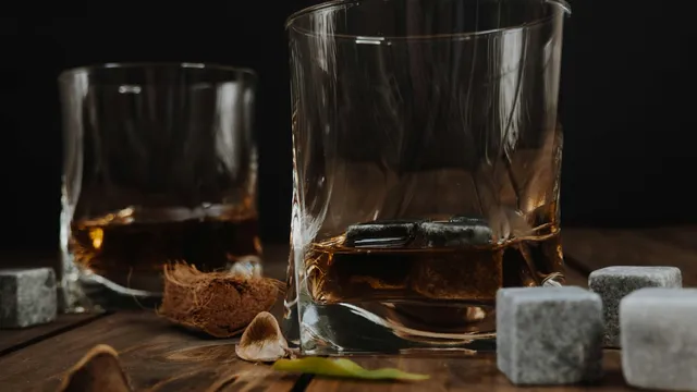 A clear glass of water resting on a dark wooden table